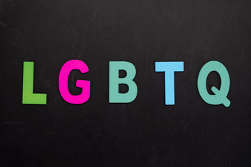 Alphabetic of colorful wooden with LGBTQ word on black background. Concept of LGBT activism.