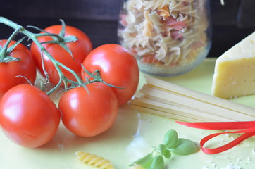 composition of healthy food ingredients on white background, top view. Ingredients for making macron, spaghetti, pasta. Tomatoes, basil, parmesan cheese, grater