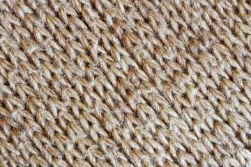 Gray with a brown tint knitted woolen fabric. Diagonal pattern. Warm clothes for winter and autumn cold. Texture for design or research