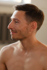 Obraz premium Closeup portrait of a smiling yoga trainer with naked torso and stubble on his face