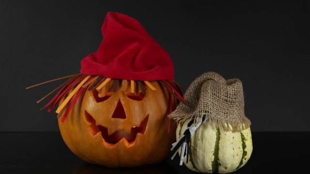 Two funny halloween pumpkins in hats are placed on a black background