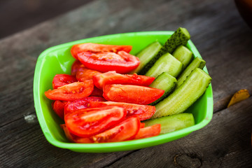 Tomatoes and cucumbers in a plate. Juicy vegetables sliced in a plate. Beautiful delicious tomatoes and cucumbers, fresh salad.