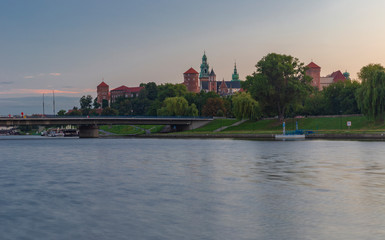 Naklejka premium Wawel castle at sunrise reflected in the Vistula river.