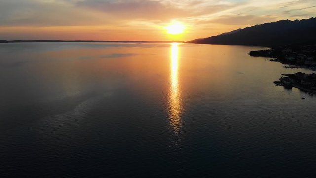 Upward Drone Pan of Colourful Sunset Over Ocean