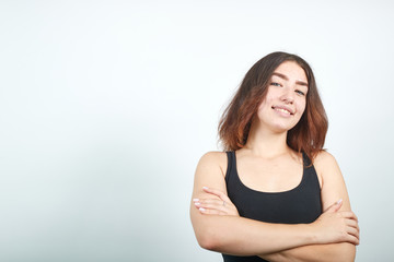 beautiful girl in black tank top over isolated white background shows emotions