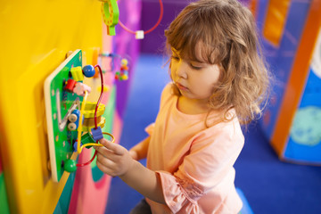 little girl playing with labyrinth educational toy