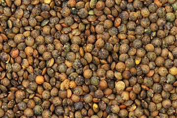 Flatlay closeup image of brown lentils as a natural healthy food background.