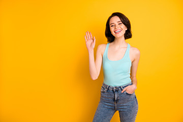 Photo of cute nice charming beautiful careless girl saying hi to you while isolated over vivid yellow background © deagreez