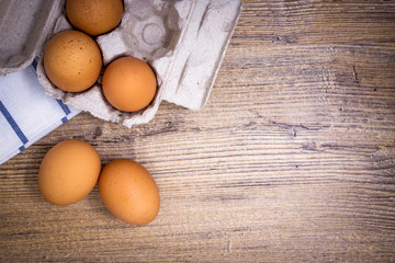 uova con contenitore di cartone su tavolo di legno