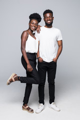 Beautiful young African couple standing close to each other and smiling at camera while isolated on...