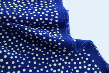 beautifully draped with soft folds bright dark blue fabric for needlework or decor, polka dot and...