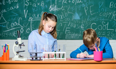 Kids busy study chemistry. School chemistry lesson. School laboratory. Girl and boy smart students conduct school experiment. Describe chemical reaction notepad. School education. Chemical analysis