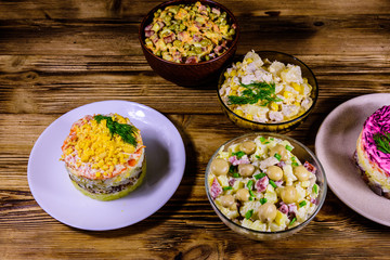 Set of festive mayonnaise salads on wooden table