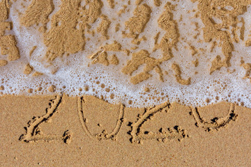 New year 2020. Inscription on a sandy beach. Tropical celebration concept