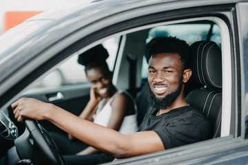 African American couple drive car in the street