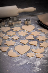 Cooking cookies with cookie cutters on a dark table