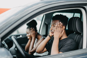 Young african shocked look couple driving car on high speed on the road