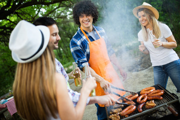 Fototapeta na wymiar Happy friends enjoying barbecue and grill party outdoor