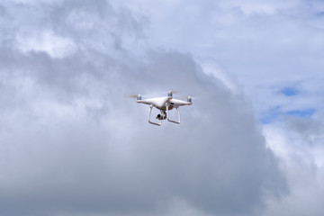 Fototapeta na wymiar White drone quadcopter flying on the air for take a photo and video with white cloudy background.