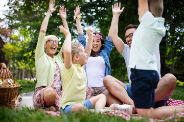 Fototapeta premium Happy family enjoying picnic in nature at summer