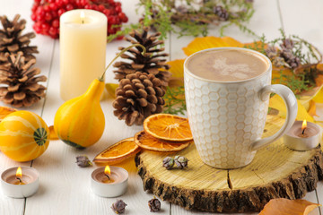 Hot autumn drink, coffee or cocoa, with yellow leaves and decorative pumpkins on a white wooden table. autumn composition.