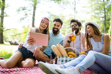 Happy young friends having fun outside in nature, taking selfie