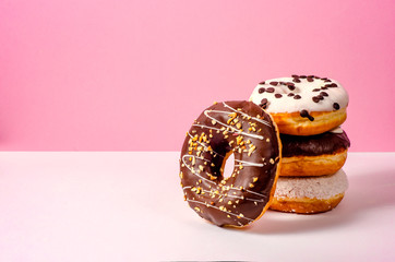 Different  chocolate donuts on pink background. Minimal concept. Donuts with chocolate glaze