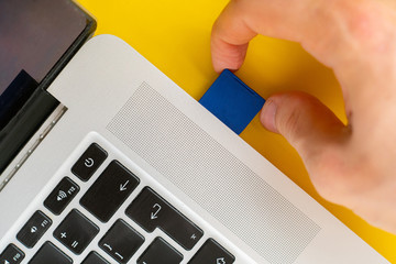 hand holding SD Flash card drive and insert it in the laptop