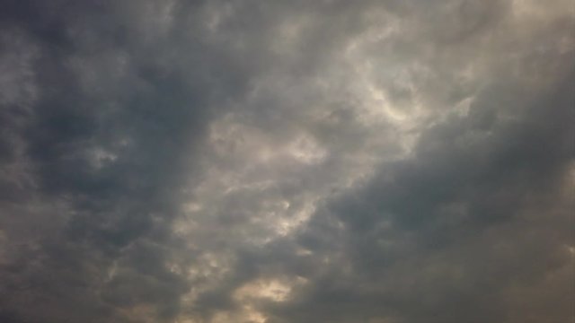 Ominous fantastic background with sky covered by layers of dark nimbostratus clouds floating in time lapse with back lit , bad weather