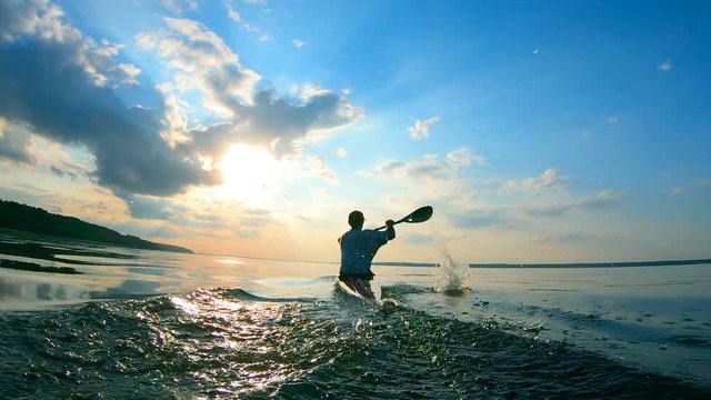 Backside view of a man sailing on a canoe