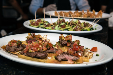Variety of modern cuisine plates line the kitchen counter ready to be served to the guests.