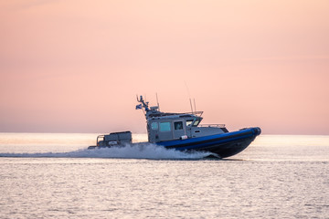 Fototapeta na wymiar A coast guard patrol boat sails near the shore