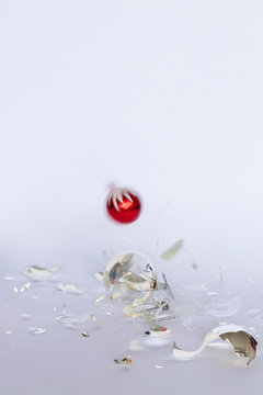 Falling and broken red and silver Christmas baubles on white background