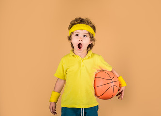 Cute boy holds basketball ball. Basketball player with ball. Adorable child playing basketball....