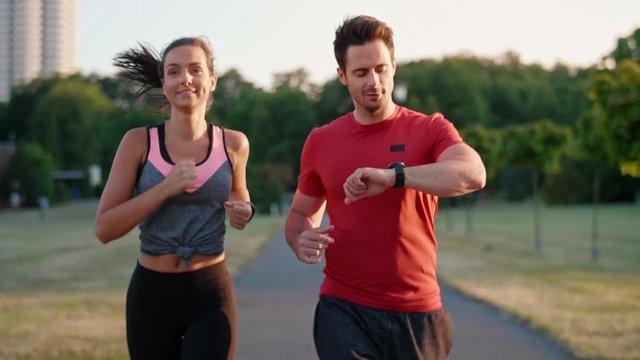 Front view of young couple jogging in the park