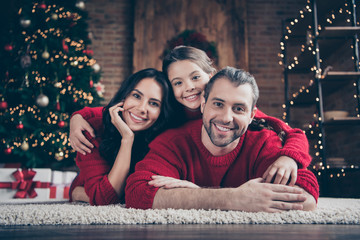 Close-up portrait of three nice attractive lovely charming cute dreamy idyllic cheerful cheery peaceful family lying on comfortable carpet festive vacation in industrial loft wood brick style interior