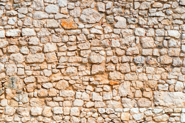 An old time damaged wall made of rough stone. Natural background for design.