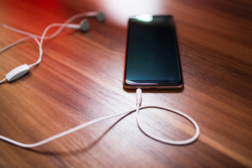 Smartphone and earphones on the table