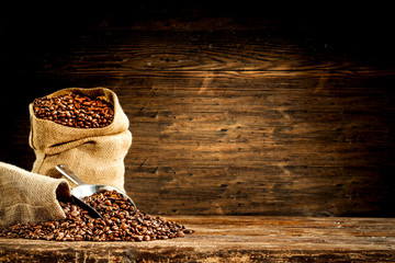 Grains de café frais dans un sac marron et espace libre pour votre décoration.