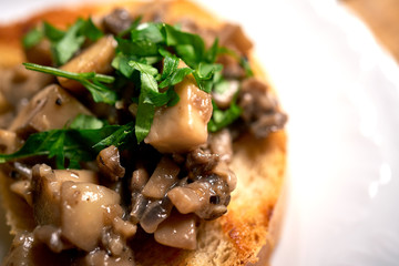 Close up of toasts with mushrooms on wooden kitchen table
