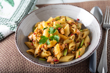 Piatto di pasta con salmone, zucchine e grani di pepe 