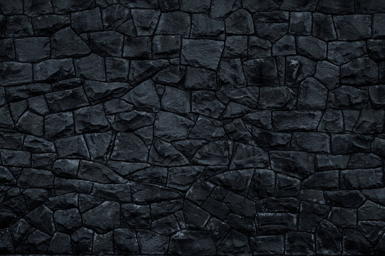 Dark stone background. Black rock wall texture. Abstract pattern. Natural backdrop. Decoration gray tiles at the facade of the building. Marble geometric element, material design.