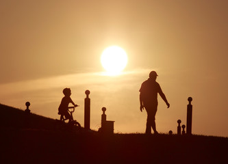 Fototapeta na wymiar silhouettes of children playing on beach at sunset
