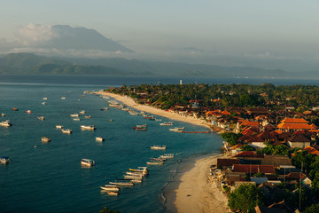 Panoramic view of the northern coast of the island of Lembongan and Jungutbatu village. Gungung Agung, the active volcano on the island of Bali is visible in the background.
