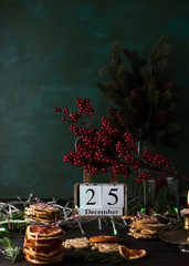 Wooden calendar with date 25 December, Christmas cookies and decor, low key image