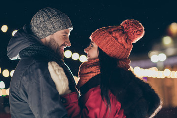 Photo of two affectionate people in love at midnight standing opposite looking eyes making newyear wish wearing warm jackets outside