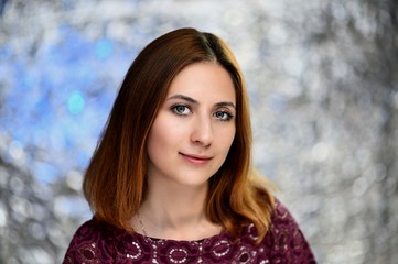 Naklejka premium A close-up portrait of a pretty brunette girl with beautiful brown hair and excellent skin on a colorful background. Smiles, happiness, beauty.