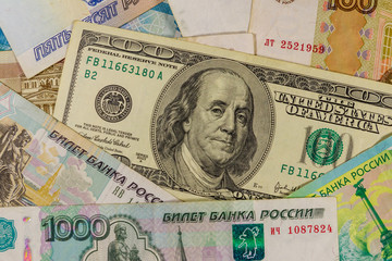 One hundred dollar bill on a background of russian rubles banknotes