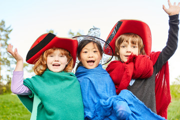 Three children celebrate carnival in colorful costumes