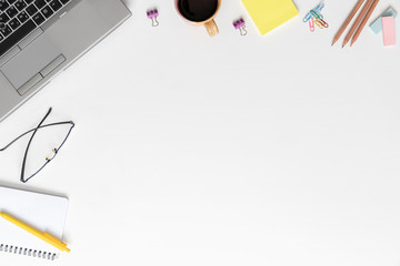 Creative designer desktop with laptop, coffee cup, supplies and other items